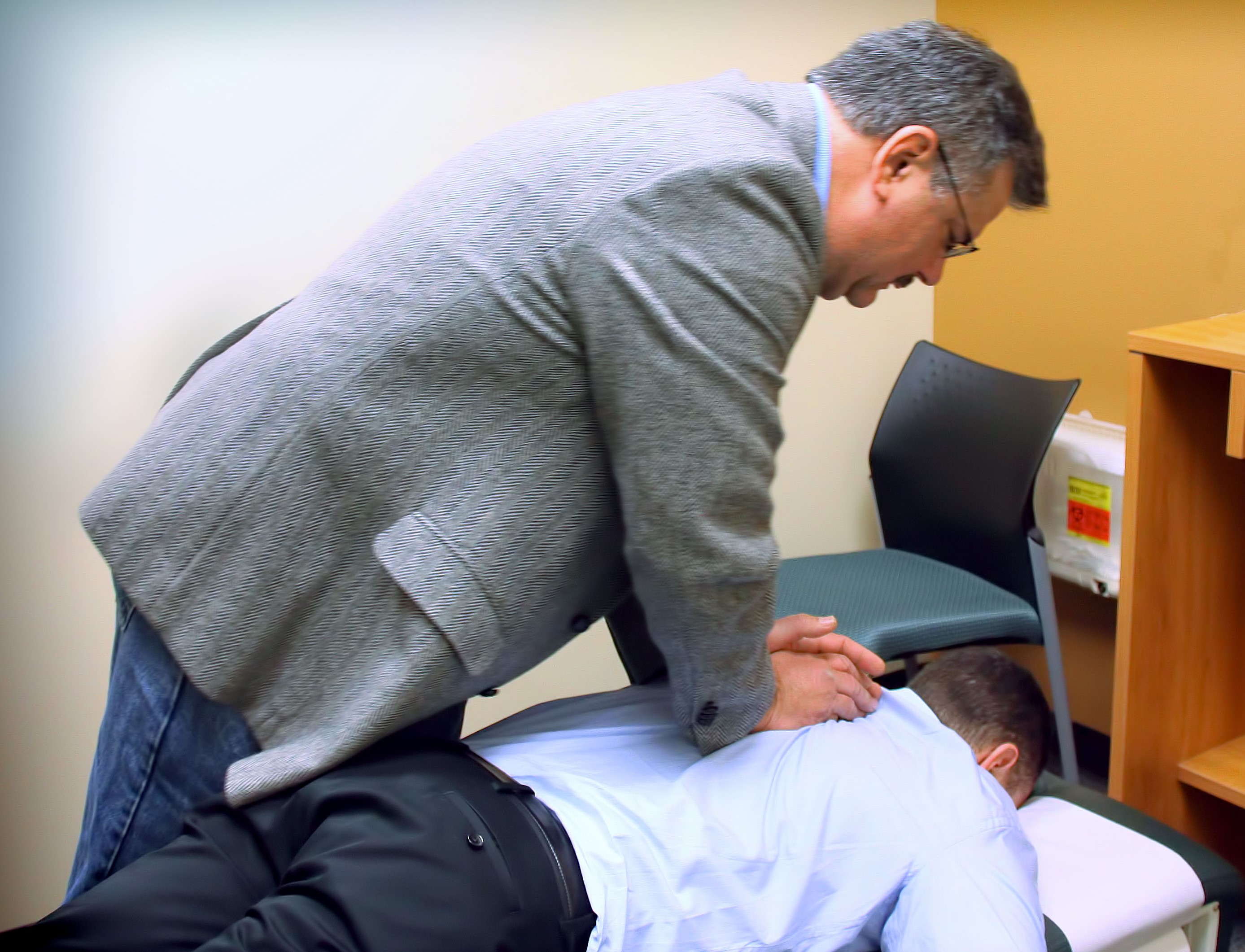 chiropractic doctor in therapy session with his patient